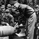Lt. Col. Doolittle attaches Japanese friendship medals, awarded before the war, to a bomb that will be dropped on Japan while pilots and crewmen look on (US Navy)